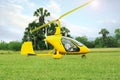 Yellow rotorcraft on grass near trees outdoors