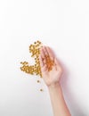 Yellow round capsules with omega-3 fish oil in a female hand on a white background. Flat lay