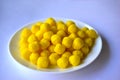 Yellow round corn snacks on a white plate Royalty Free Stock Photo