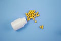 Yellow round pills spilling out of a toppled of a white bubble Royalty Free Stock Photo