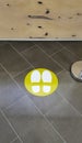Yellow round sign printed on ground at supermarket cash desk register informing people to keep 2 meter 6 feet distance Royalty Free Stock Photo