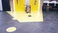 Yellow round sign printed on ground at supermarket cash desk register informing people to keep 2 meter 6 feet distance Royalty Free Stock Photo