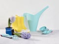 Yellow rubber boots and blue watering can with a bouquet of flowers of yellow daffodils and white and pink tulips on the white bac Royalty Free Stock Photo