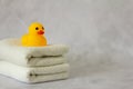 A yellow rubber duck for bathing on a stack of clean white towels Royalty Free Stock Photo