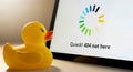 Yellow rubber duck beside a computer screen displaying a loading symbol and error message Royalty Free Stock Photo