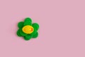 Yellow rubber duck on a green plastic waste pollution island on a pink pastel background. Polluted environments. Flat lay
