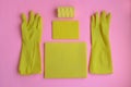 Yellow rubber gloves and different washcloths and cleaning rags on pink background. Cleaning or housekeeping concept background.