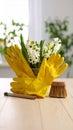 Yellow rubber gloves, flowers, and cleaning tools on a wooden surface Royalty Free Stock Photo