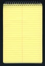 Yellow ruled spiral notepad over black