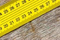 Yellow ruler on a wooden background Royalty Free Stock Photo