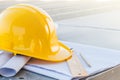 The yellow safety helmet and the blueprint at construction site. Royalty Free Stock Photo