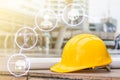 The yellow safety helmet and the blueprint at construction site with crane background Royalty Free Stock Photo