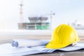 The yellow safety helmet and the blueprint at construction site Royalty Free Stock Photo