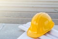 The yellow safety helmet and the blueprint at construction site Royalty Free Stock Photo