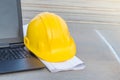 The yellow safety helmet with the blueprint and laptop at construction site Royalty Free Stock Photo