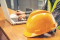 The yellow safety helmet and Business man in Construction industry is taking note on computer Royalty Free Stock Photo