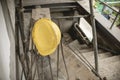 A yellow safety helmet hangs on some exposed rebars at a construction site during break time