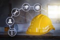 The yellow safety helmet put on the blueprint at construction site with icon technology Royalty Free Stock Photo