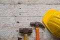 yellow safety helmet and rolled up architectural blueprints on a wooden desk