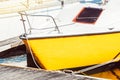 Yellow sailboat moored at marina dock with sunlit reflections, background Royalty Free Stock Photo
