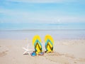 Yellow sandal on beige sand summer beach background Royalty Free Stock Photo