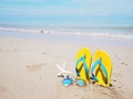 Yellow sandal on beige sand summer beach background Royalty Free Stock Photo