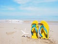 Yellow sandal on beige sand summer beach background Royalty Free Stock Photo