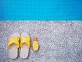 Yellow sandal and sunscreen lotion by swimming pool Royalty Free Stock Photo