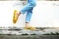 Yellow Sandals. Woman Wearing Flip Flops and Blue Jeans Standing on Old Cement Floor