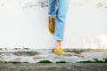 Yellow Sandals. Woman Wearing Flip Flops and Blue Jeans Standing on Old Cement Floor