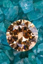 yellow sapphire diamond on placed on a pile of raw sky blue gemstones