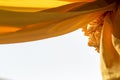 Yellow sateen rolls and hanging to decorate the arch