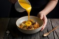 Yellow sauce being poured into a bowl, a culinary delight