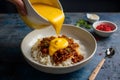 Yellow sauce being poured into a bowl, a culinary delight