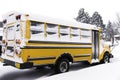 Yellow school bus covered with snow parked in a residential neighborhood on a snow day Royalty Free Stock Photo