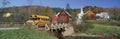 Yellow school bus crossing wooden bridge over Waits River in autumn, VT