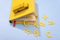 A yellow school bus drives over a book with large letters back to school. concept photo