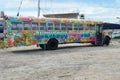 Yellow school bus painted with graffiti and used in the past as party bus parked in scrapyard in Nassau, Bahamas. Royalty Free Stock Photo
