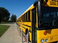 Yellow school bus parked along sidewalk curb