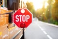 Yellow school bus with red stop sign standing on the road Royalty Free Stock Photo