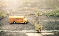Yellow school bus toy model on country road. Royalty Free Stock Photo