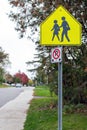 Yellow school crossing ahead sign on the road near school zone