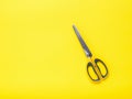 Yellow scissors on a yellow background in minimalism style.