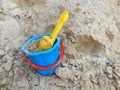 Yellow scoop and blue bucket in the sandbox. Photo of children sandbox