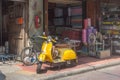 Yellow scooter parked on pavement in Chinatown, Bangkok, Thailand