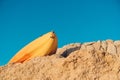 Yellow sea kayak on stone and sky background