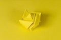 Yellow origami seashell on yellow background