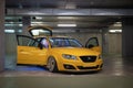 yellow Seat Exeo ST with the doors and trunk open in an underground garage