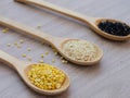 Yellow sesame, white sesame, and black sesame seed on wooden spoon, concept of healthy food. Royalty Free Stock Photo