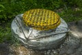 Yellow sewer cast-iron manhole cover on concrete base